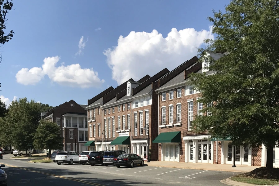 A row of downtown brick shops with green awnings in Cornelius, North Carolina