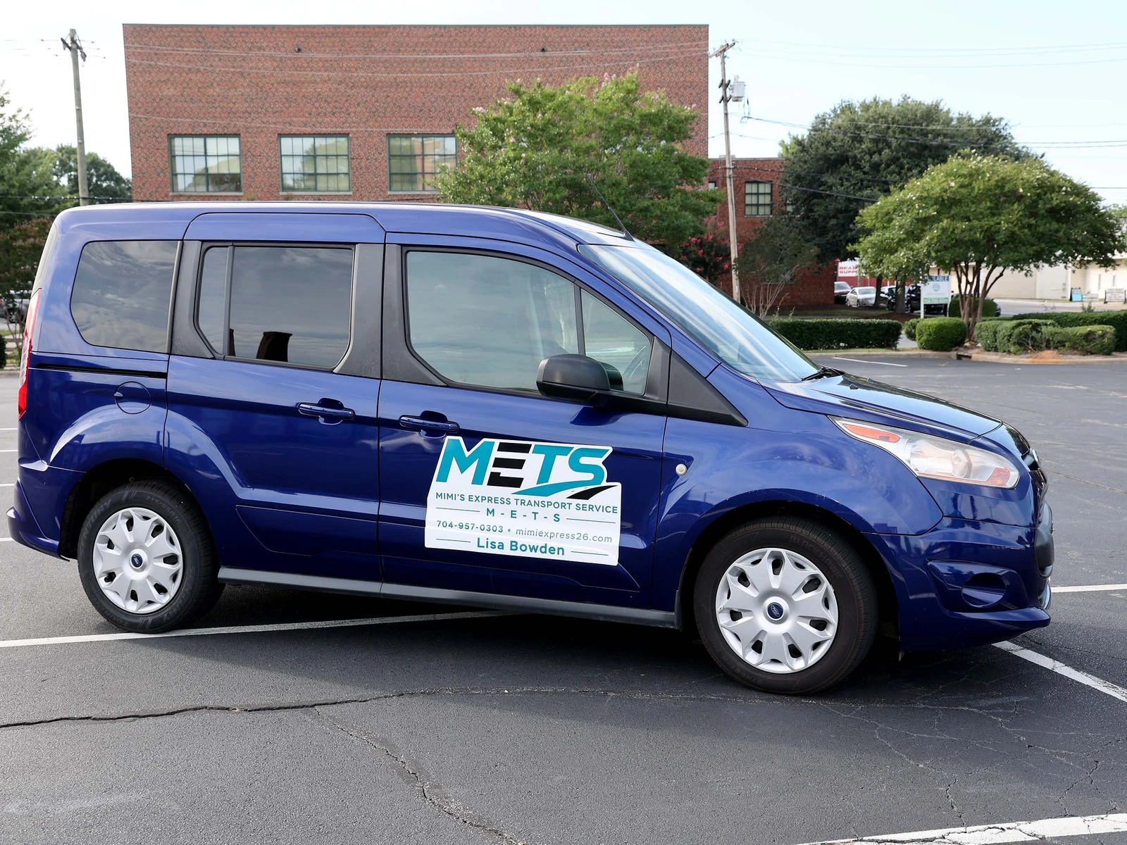 Mimi's Express Transport Services blue Ford Transit van with the METS logo, parked in a Charlotte, NC lot.